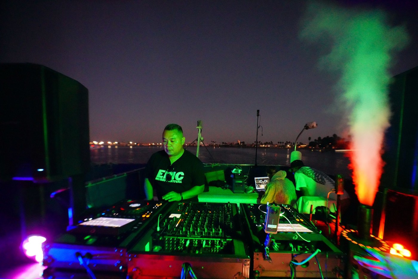 Boat deck at night with the city skyline behind